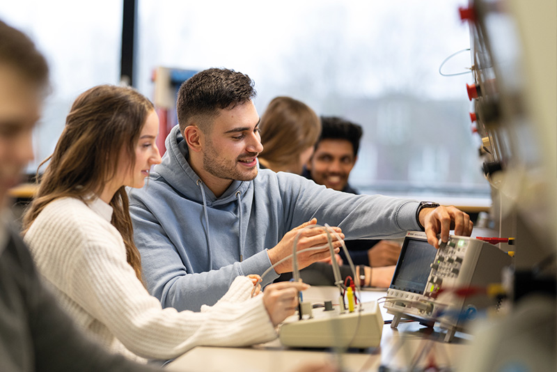 Studierende bedienen im Labor ein Oszilloskop