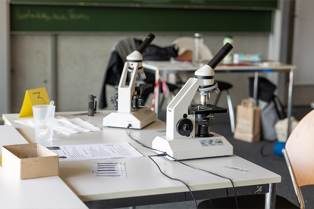 Ein Tisch mit zwei Mikroskopen und Zetteln