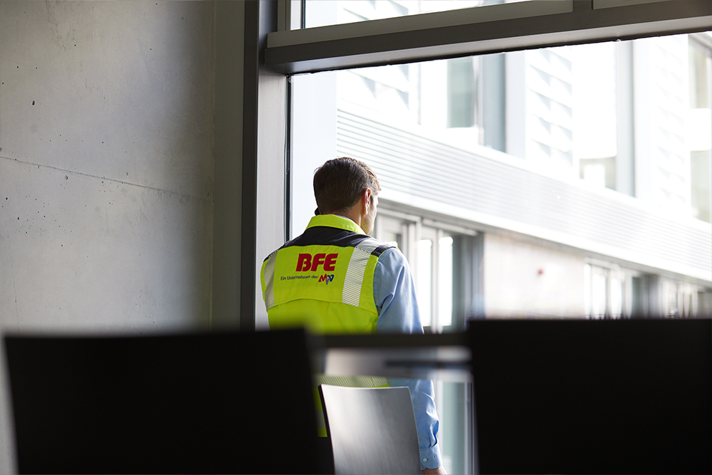 BFE-Mitarbeiter in einem Konferenzraum und schaut aus dem Fenster
